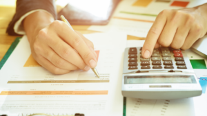 a person is using a calculator on a desk