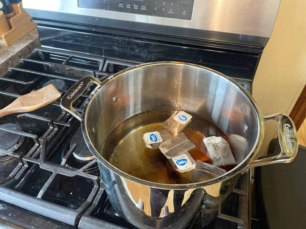 tea brewing for kombucha in pot on stove