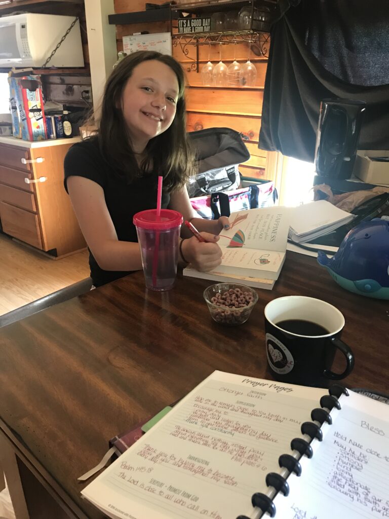kid sitting at table with books