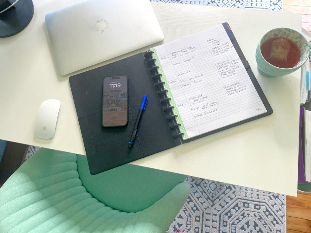 paper planner, pen, phone, laptop and tea on desk